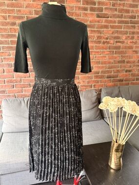Black pleated skirt with all over faces print